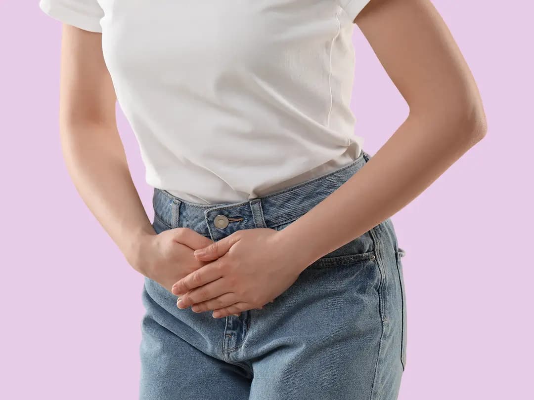 A woman holding her lower abdomen
