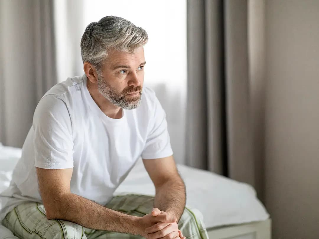 A man sitting on the edge of a bed